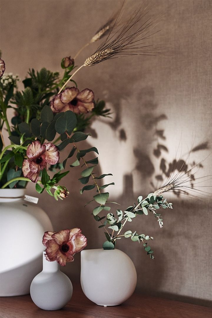 Små vaser fra Cooee Design og DBKD står på en skjenk med snittblomster fra Blombruket. 