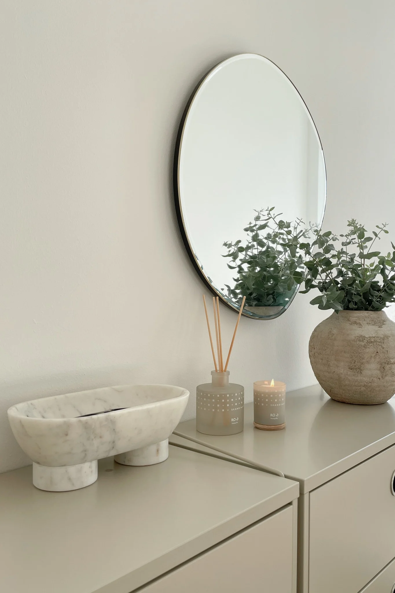 Naturmaterialer som Alza-skålen i marmor fra ferm LIVING og duftlys og duftpinner fra Skandinavisk setter et luksuriøst preg på et soverom i skandinavisk stil.