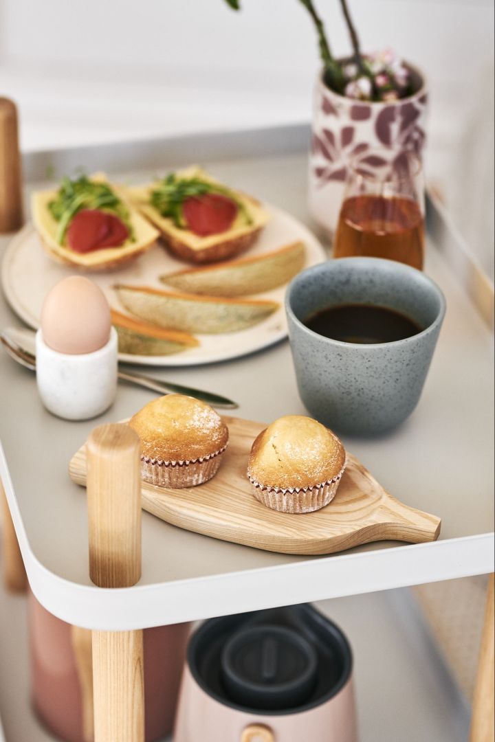 Søte muffins servert på et trebrett sammen med nytraktet kaffe blir en luksuriøs frokost og en god start på helgen.