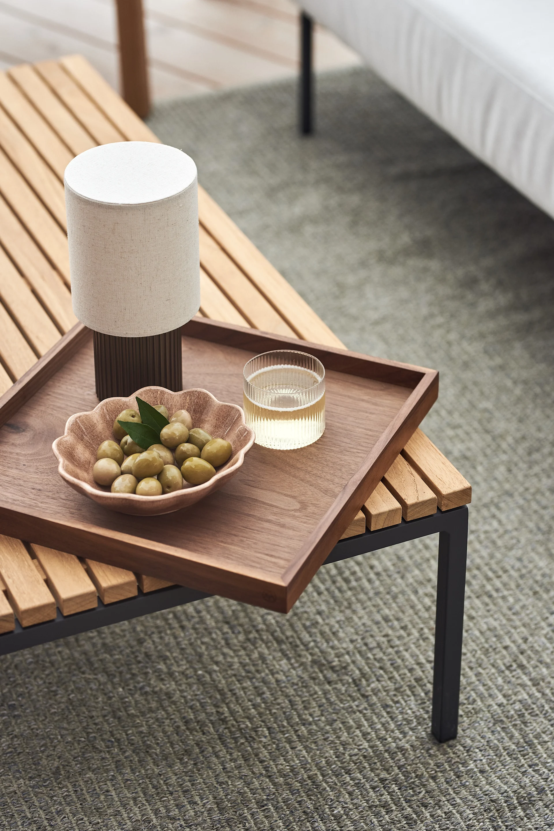 Balkonginspo med fokus på belysning, her den bærbare lampen Manhattan fra &Tradition plassert på uteplassen.