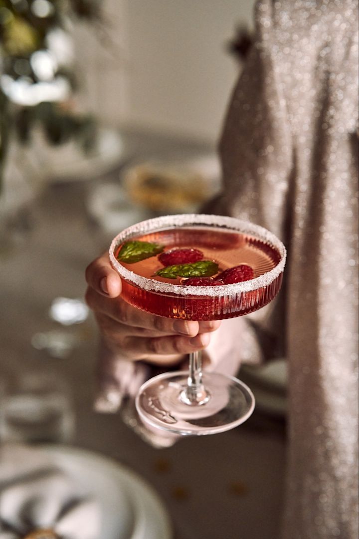 Ulike typer cocktailglass og brukes til forskjellige typer cocktailer. Her ser du en hånd som holder Ripple-glasset fra ferm LIVING.