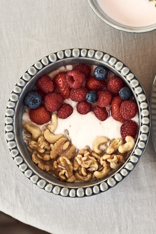 Smoothie bowl til frokost med bringebær, cashewnøtter, valnøtter og yoghurt servert i en dyp skål fra PotteryJo.