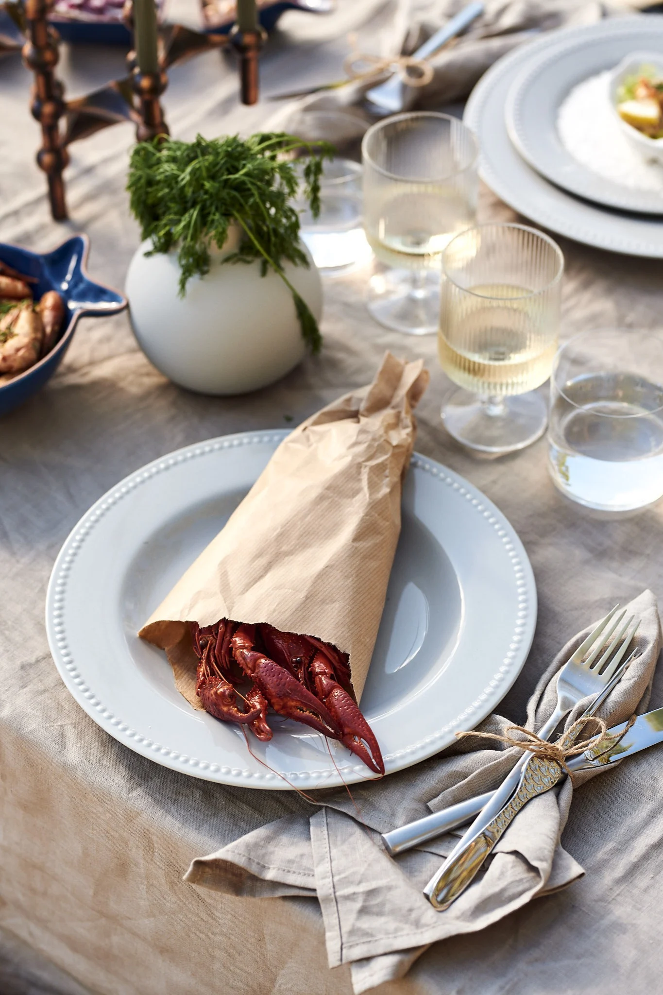 Serveringstips til sjømatkvelden - server krepsen pakket inn i vokspapir på tallerkenen.