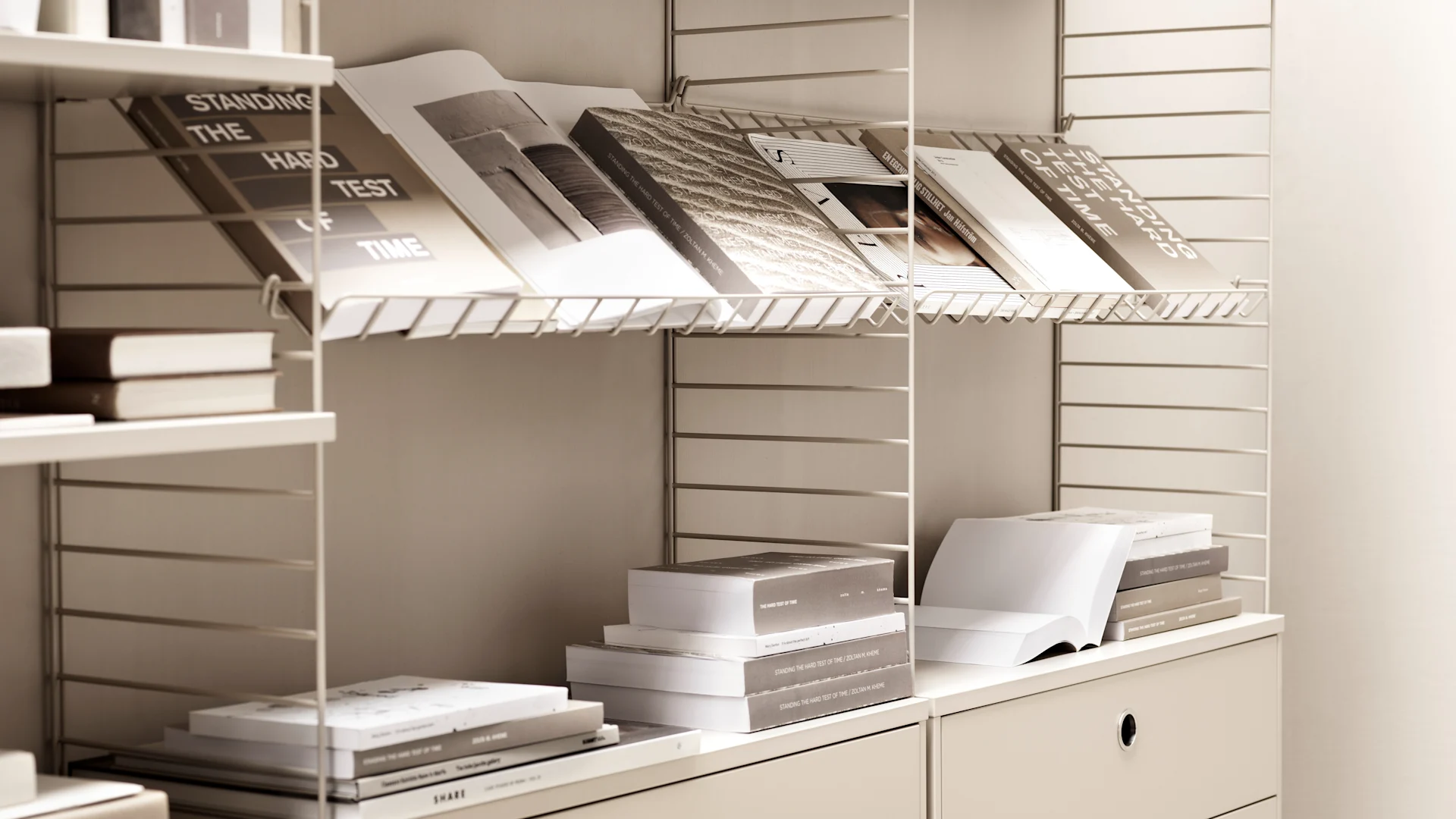 Her ser du en hvit String-hylle med bøker.