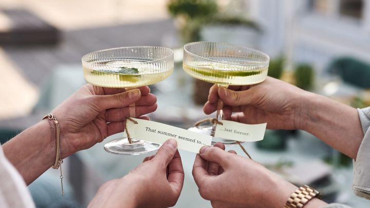 Lapper med kjente sommersanger har blitt knyttet rundt Ripple champagneglass som bordkort på hagefesten.