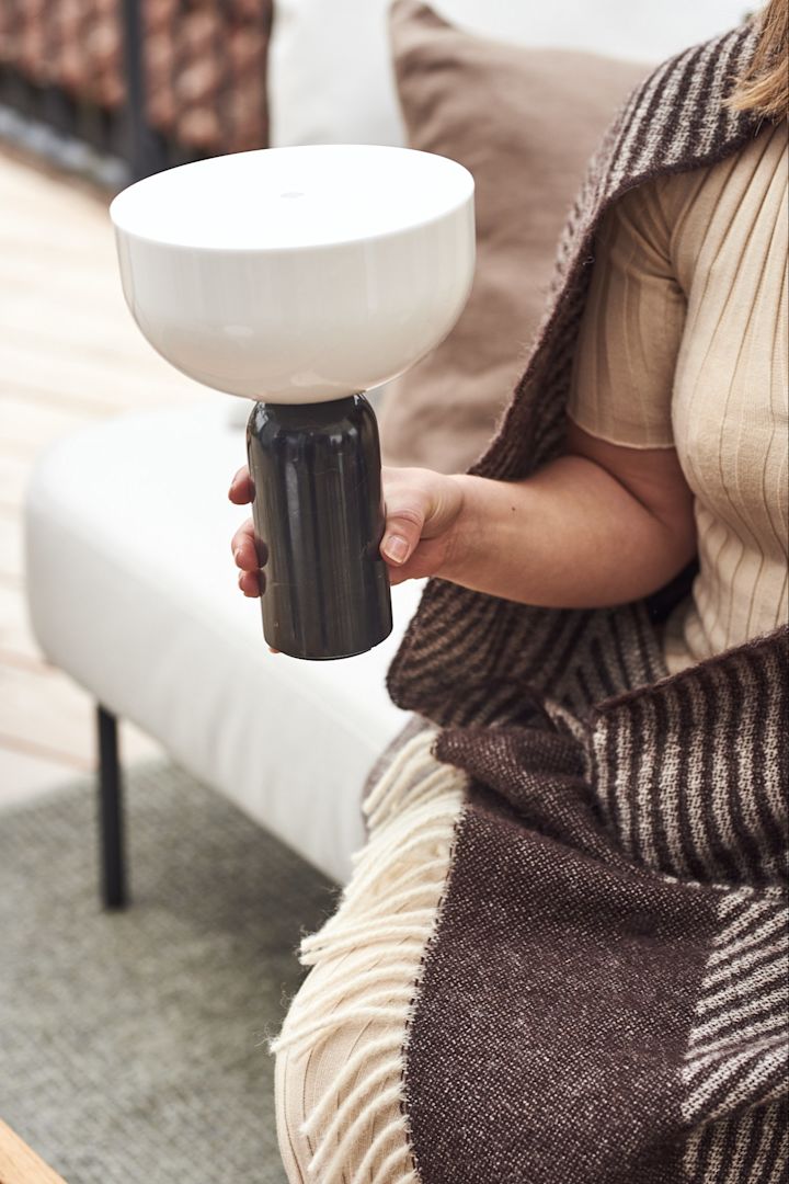 Kizu bærbar og oppladbar lampe fra New Works holdes i hånden.