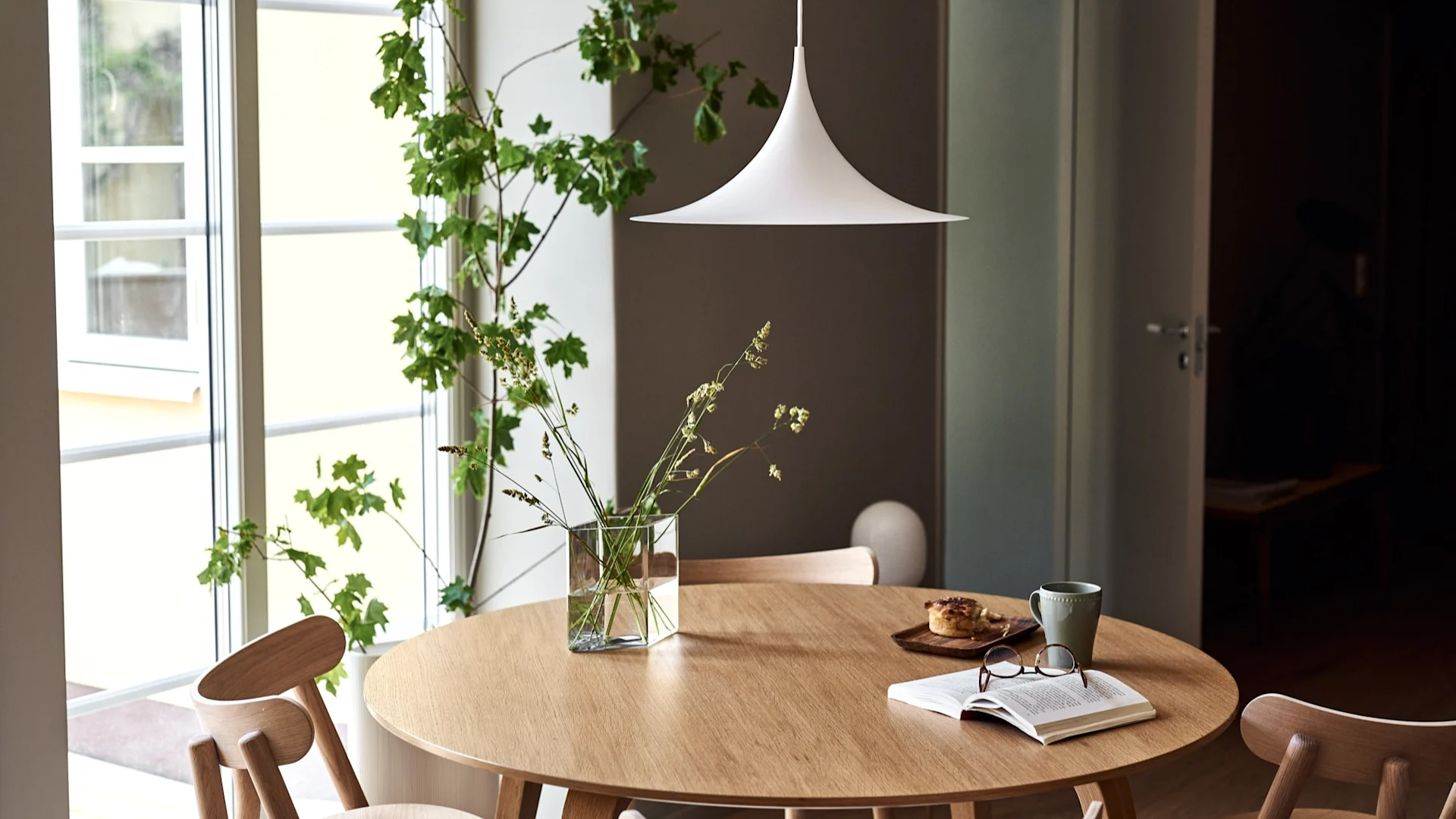 Oppdag GUBIs belysningstips for hjemmet. Her kan du se Semi pendellampe hengende over et spisebord.