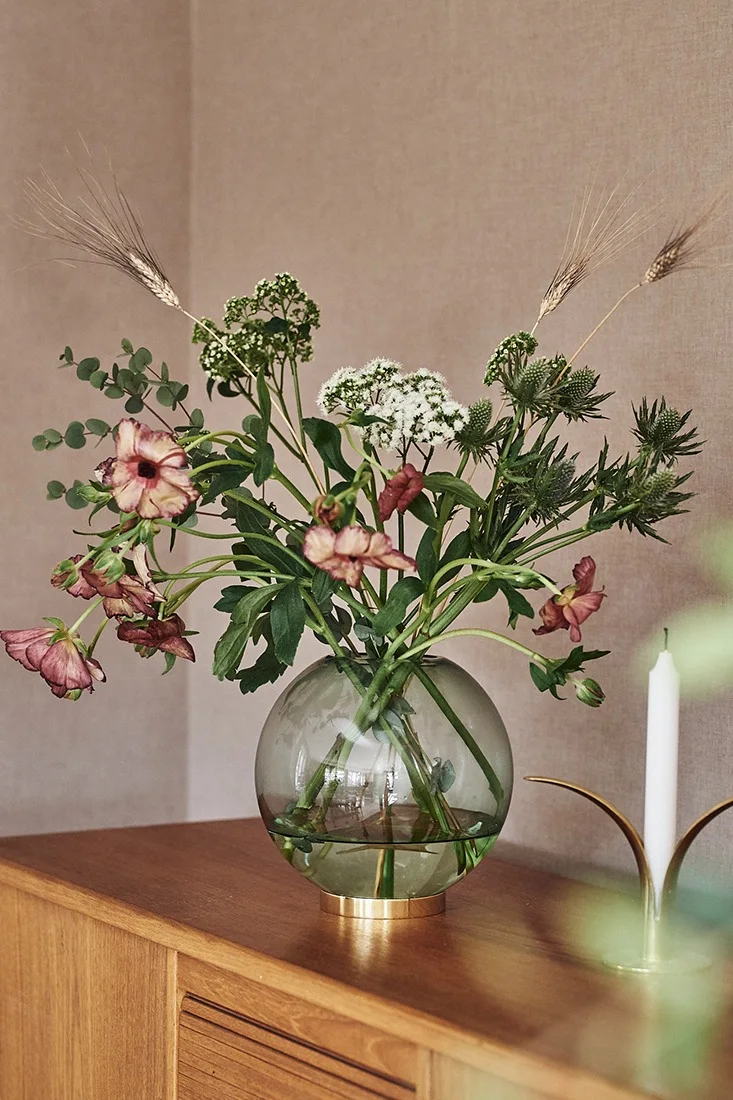 Grønn, rund vase til snittblomster i grønn farge fra AYTM med blomster fra Blombruket.