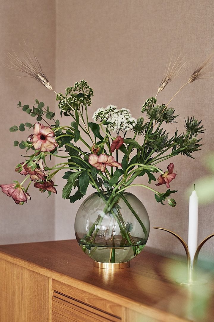 Grønn, rund vase til snittblomster i grønn farge fra AYTM med blomster fra Blombruket.