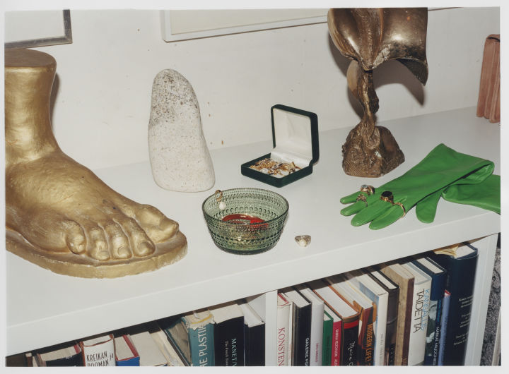 Iittala går inn i en ny æra men produktene er de samme, her Kastehelmi skål i grønt på en skjenk med statuer og hansker.