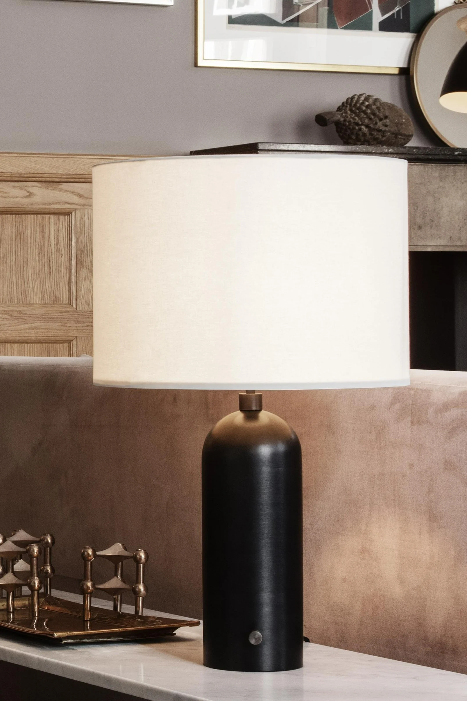 Gravity bordlampe i hvit marmor på et sidebord foran et speil.