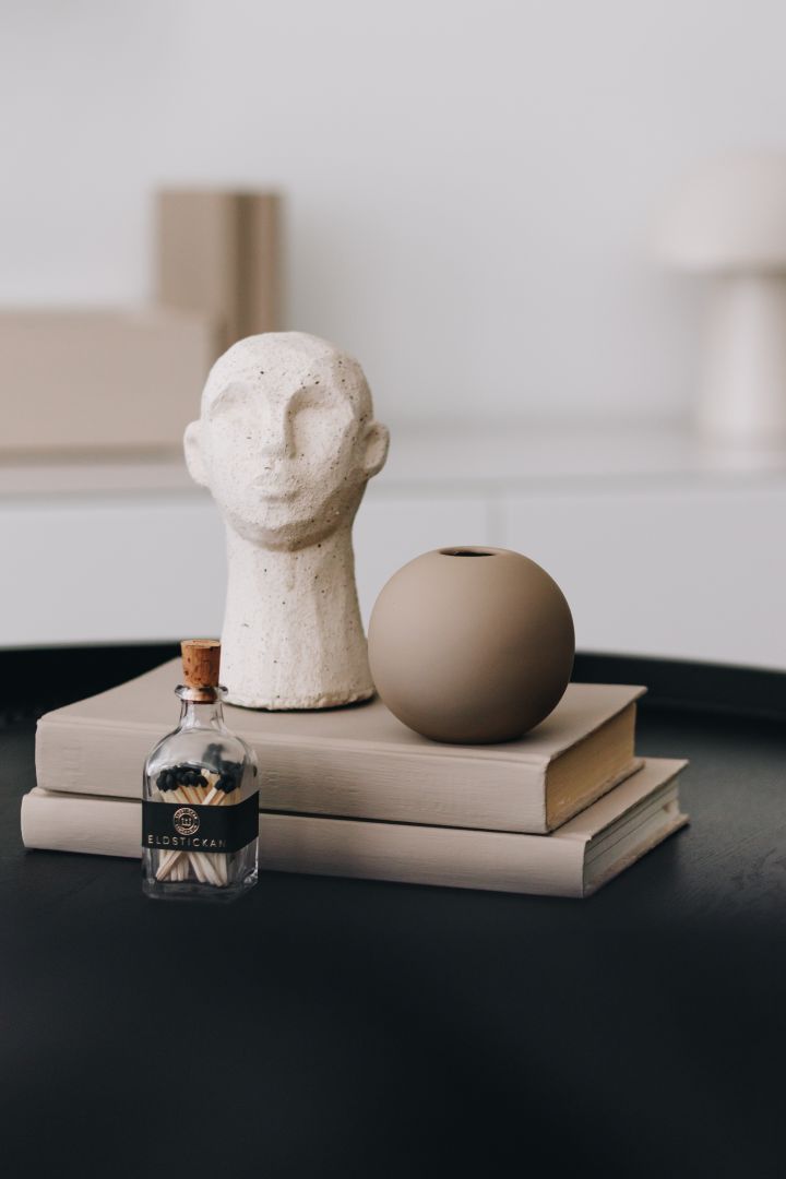 Stilig stilleben til stua til Instagram-profilen @bythun med liten vase, skulptur og bøker i ton-i-ton.