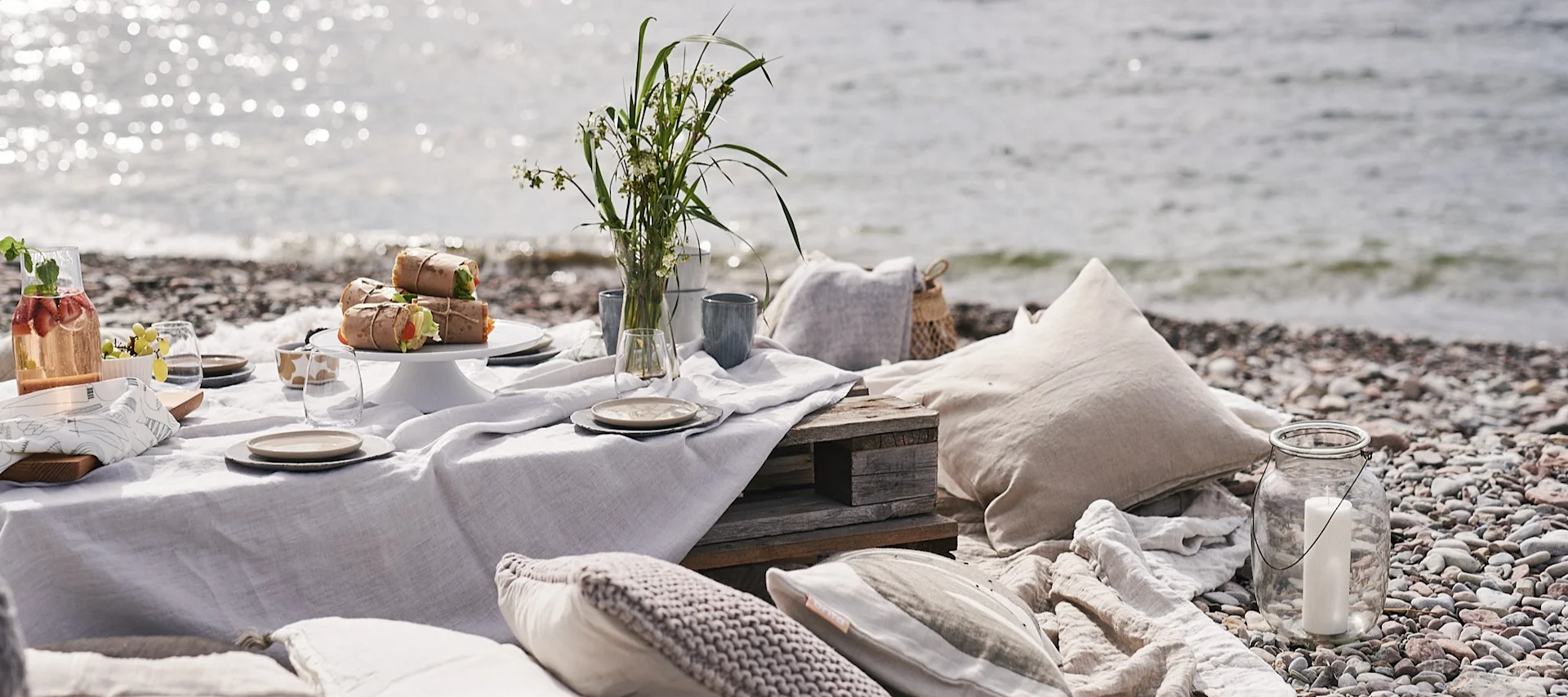 En luksuspiknik på stranden med paller som bord.