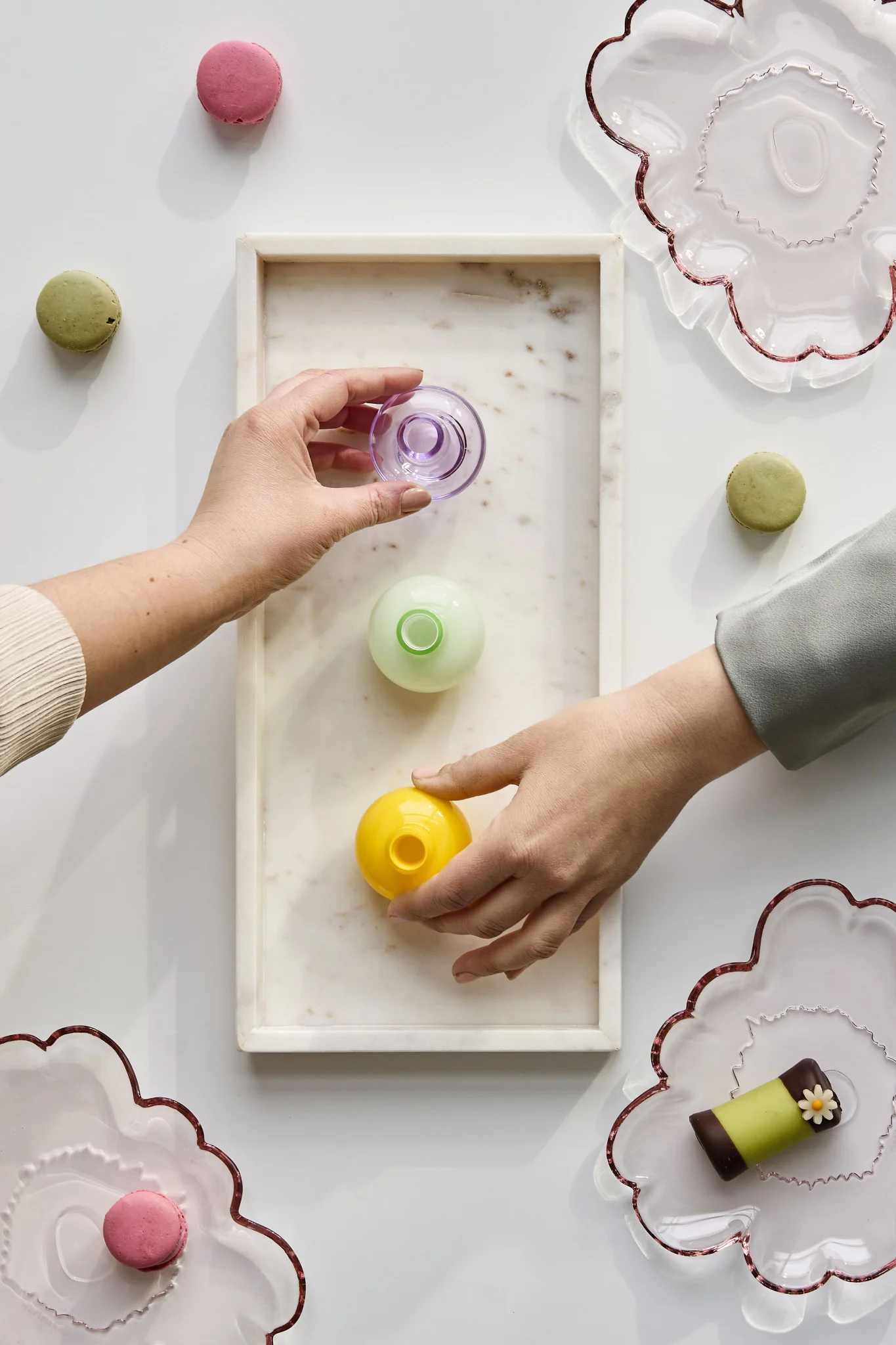 Hender griper små vaser i ulike farger for å ta med hjem som festgaver. Oppdag hvordan du arrangerer en fest med en uforglemmelig atmosfære.