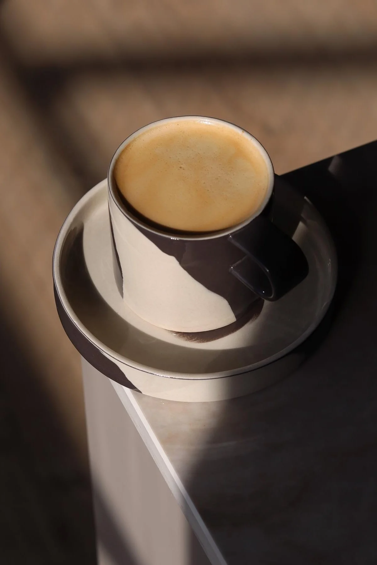 Det svart-hvite mønstrede Inlay-kruset fra Ferm Living står på et bordhjørne hjemme hos @saraelineeriksen.
