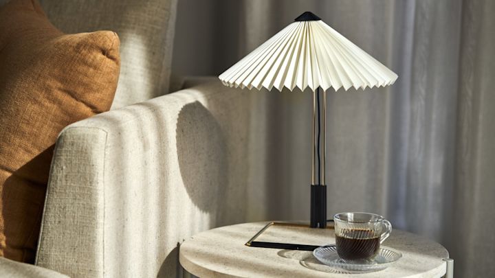 Trendy Matin bordlampe i hvitt, gull og svart med en plissert skjerm från HAY.
