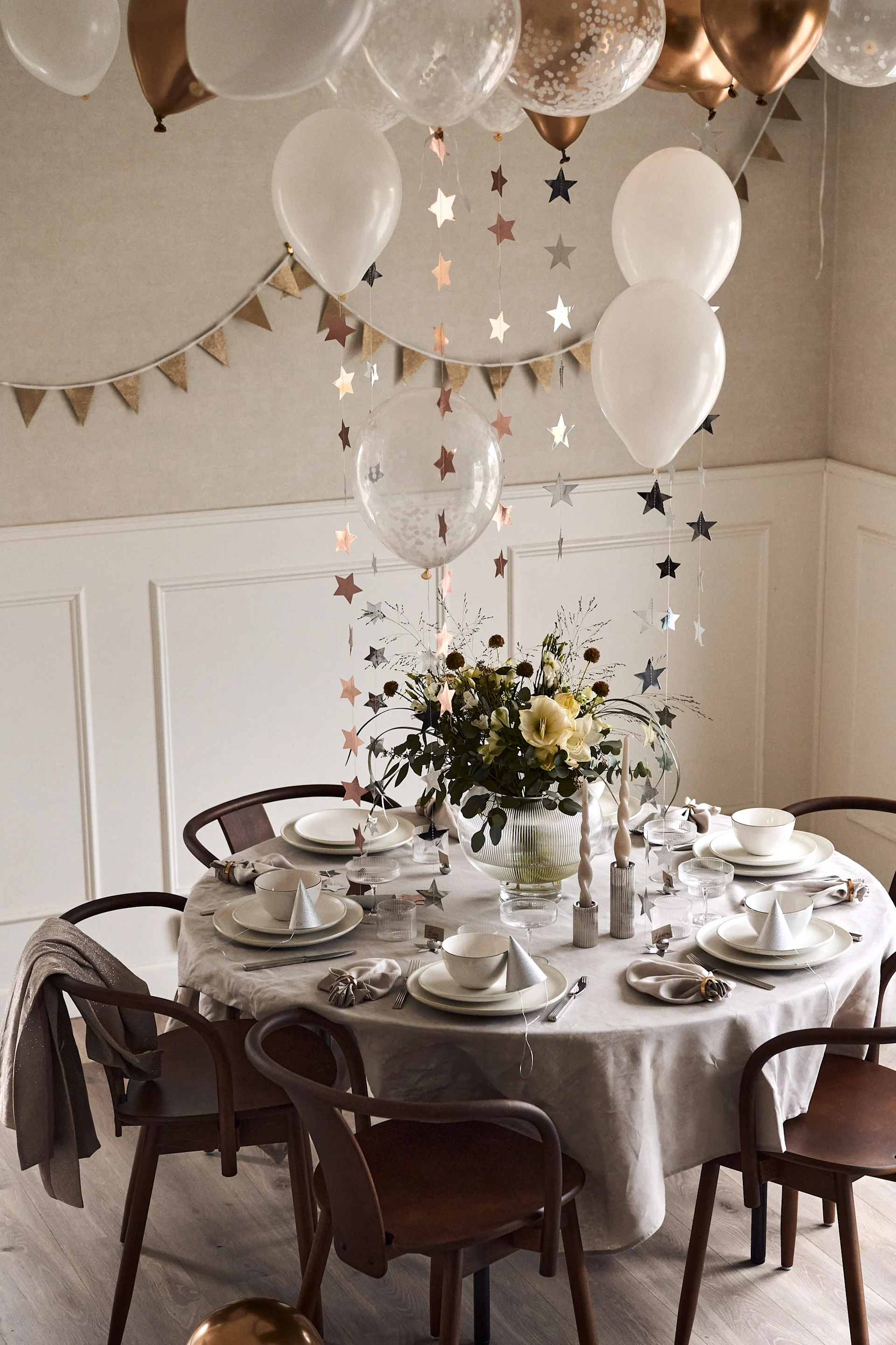 Lag din egen ballonghimmel med stjernegirlanger til årets nyttårsbord 2023 for å heve feststemningen ytterligere. 