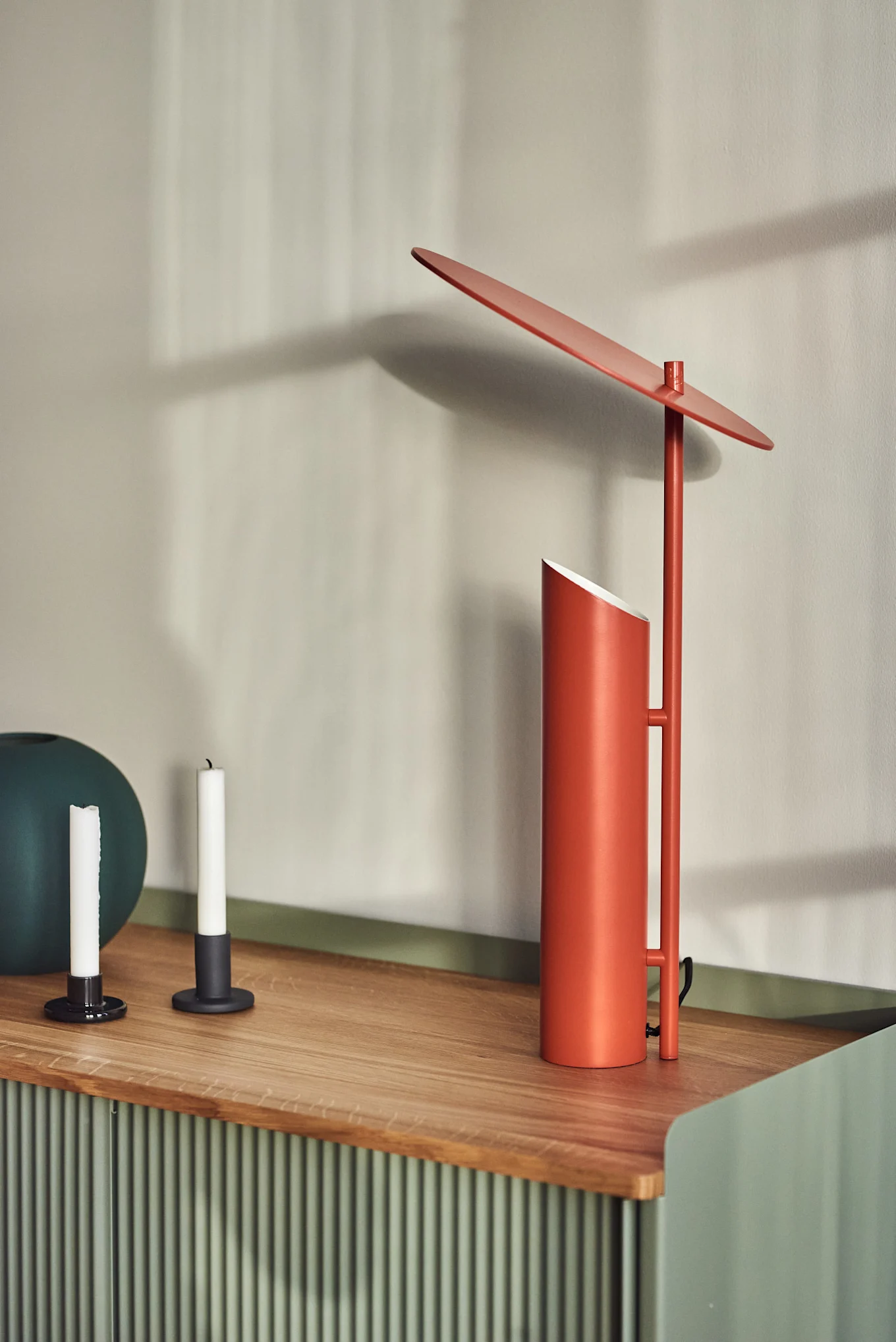 På en skjenk står den røde Reflect bordlampen fra Verpan, designet av Verner Panton.
