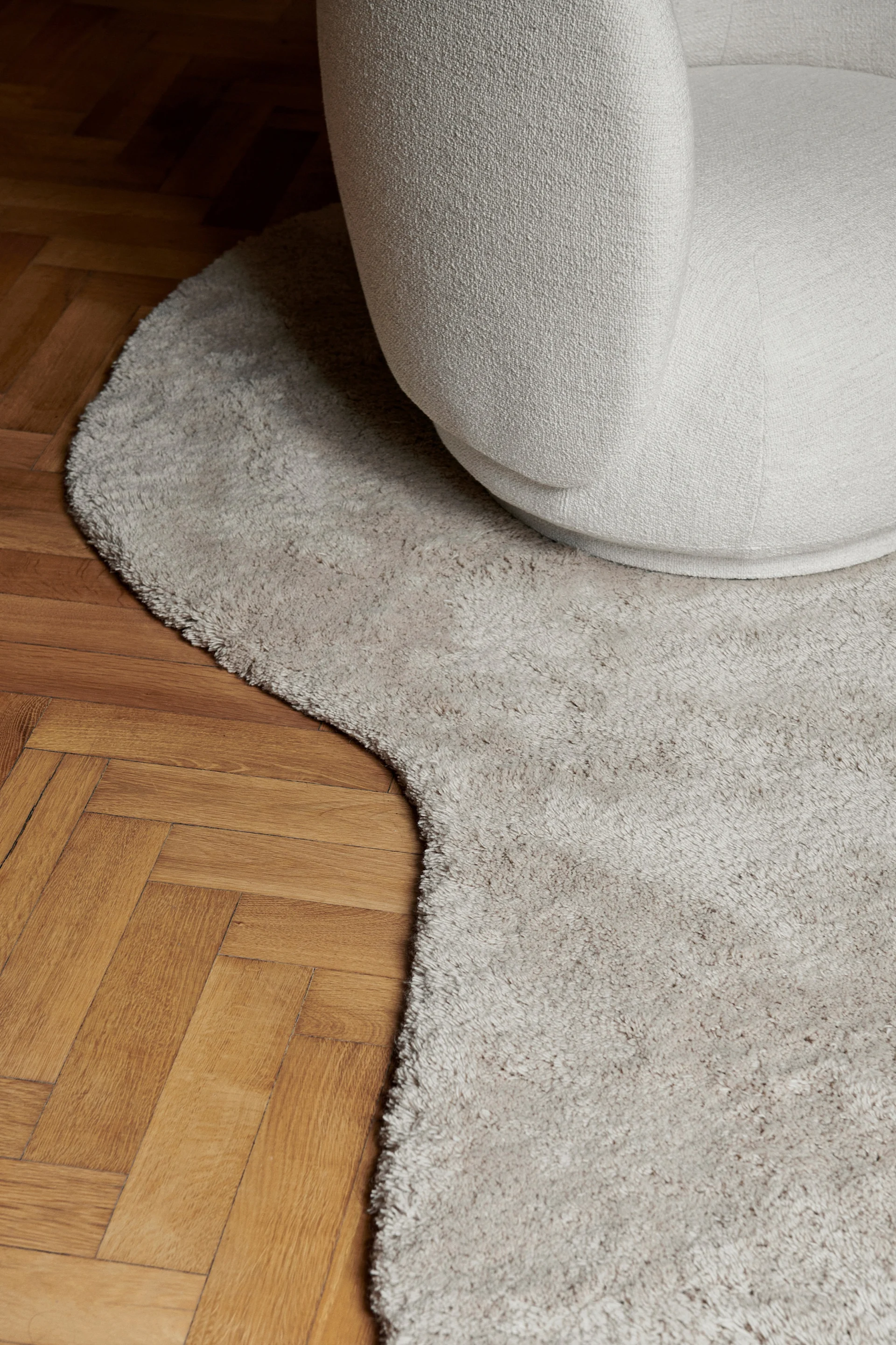 Taktil og organisk design er en av de store interiørtrender 2024 og her representert i det bølgete, hvite teppet fra ferm Living.