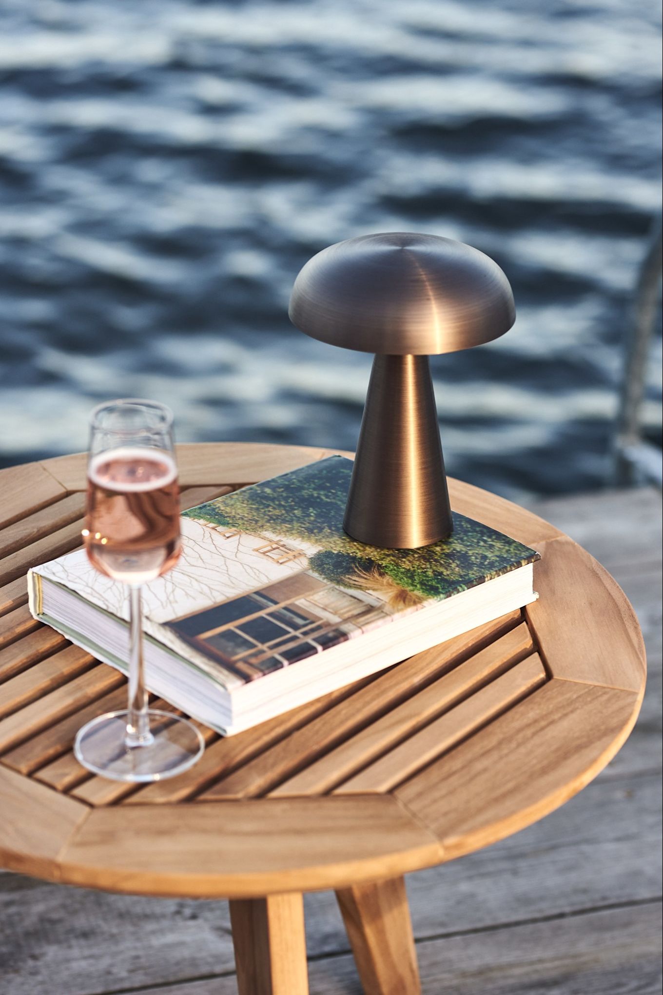 Det beste med en oppladbar lampe er at de kan følge deg uansett hvor du går – som her hvor Como-lampen fra &tradition lyser opp lesestunden på brygga.
