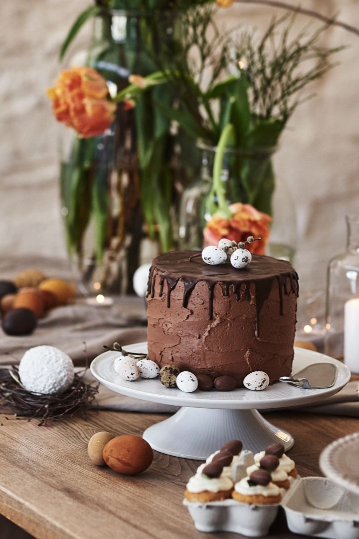 En sjokoladepåskekake ønsker gjestene velkommen til buffébordet ved påskefeiringen, der den står på et Swedish Grace-kakefat fra Rörstrand.