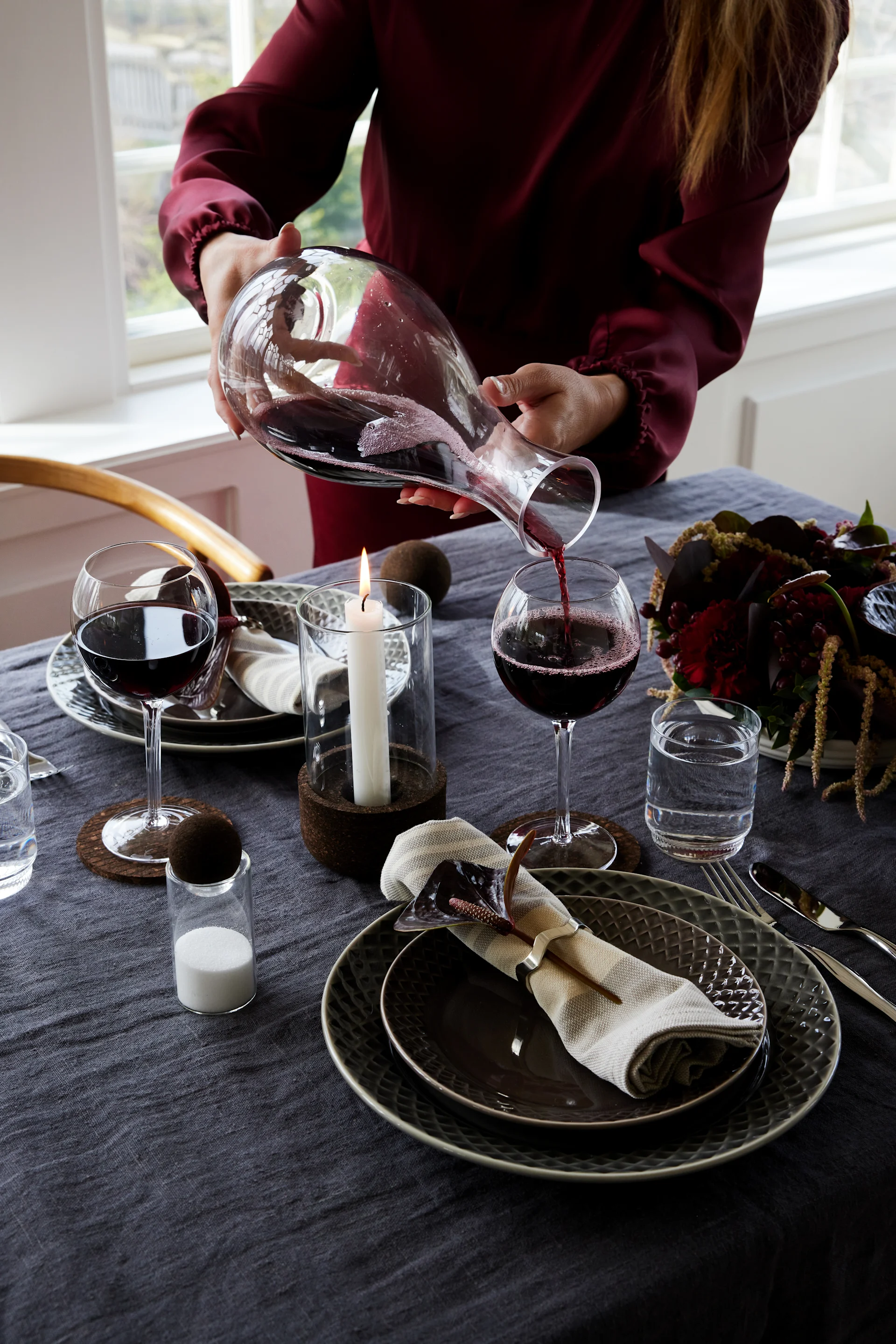 En helhetlig borddekking skaper en stemningsfull og romantisk atmosfære. Dekk bordet i mørke toner og fullfør uttrykket med små, stilige detaljer.