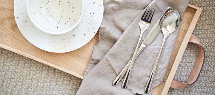 Bestikkguide - vedlikeholdsråd for rengjøring av bestikk. Polar bestikk i rustfritt stål ved siden av kuvert med Freckle porselen fra Scandi Living. 
