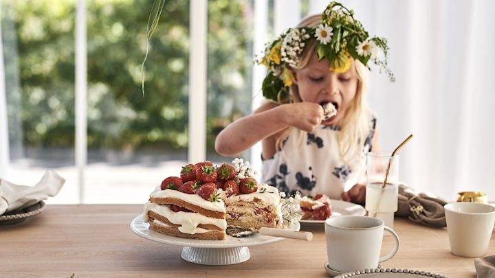 En jordbærkake på et hvitt kakefat med ERNST kakespade. 