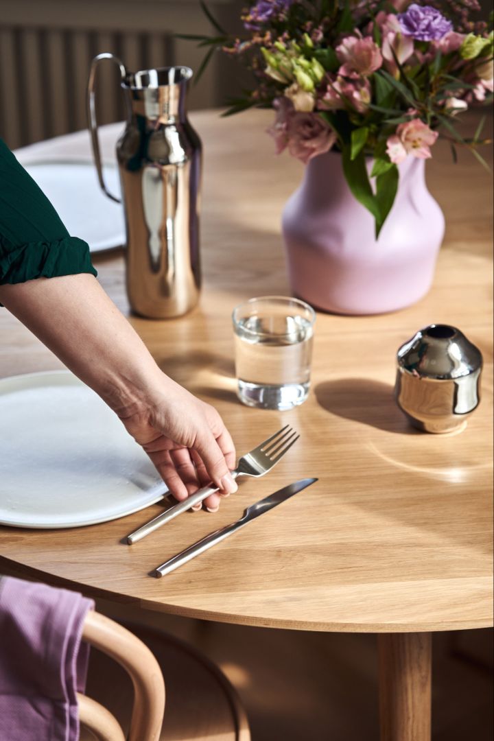 En hånd plasserer en gaffel fra den originale bestikkserien Dorotea fra den svenske merkevaren Gense, på bordet.