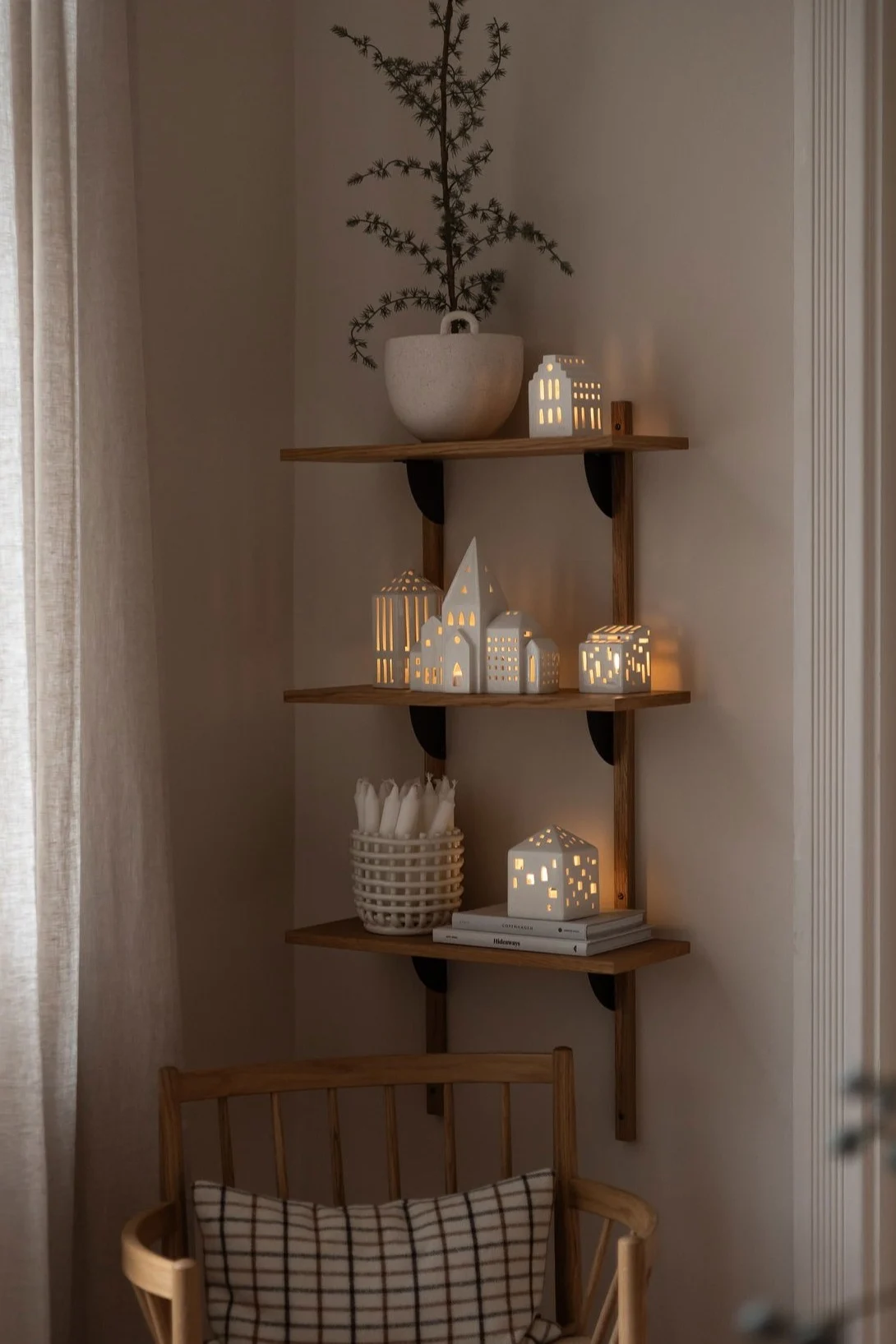 Minimalistisk julepynt i en stue med nøytrale beige- og hvittoner. Her ser du Urbania-lysholdere fra Kähler på salongbordet.