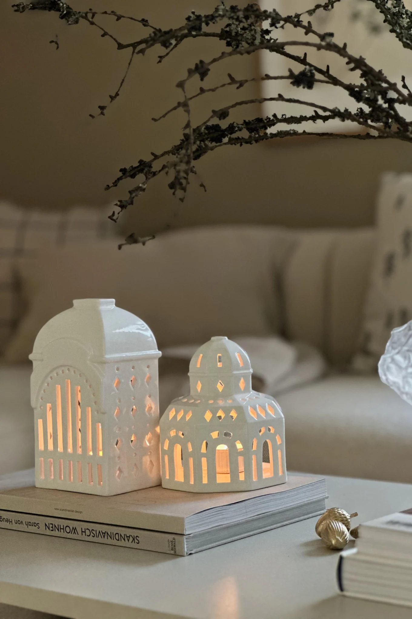 Minimalistisk julepynt i en stue med nøytrale beige- og hvittoner. Her ser du Urbania-lysholdere fra Kähler på salongbordet.