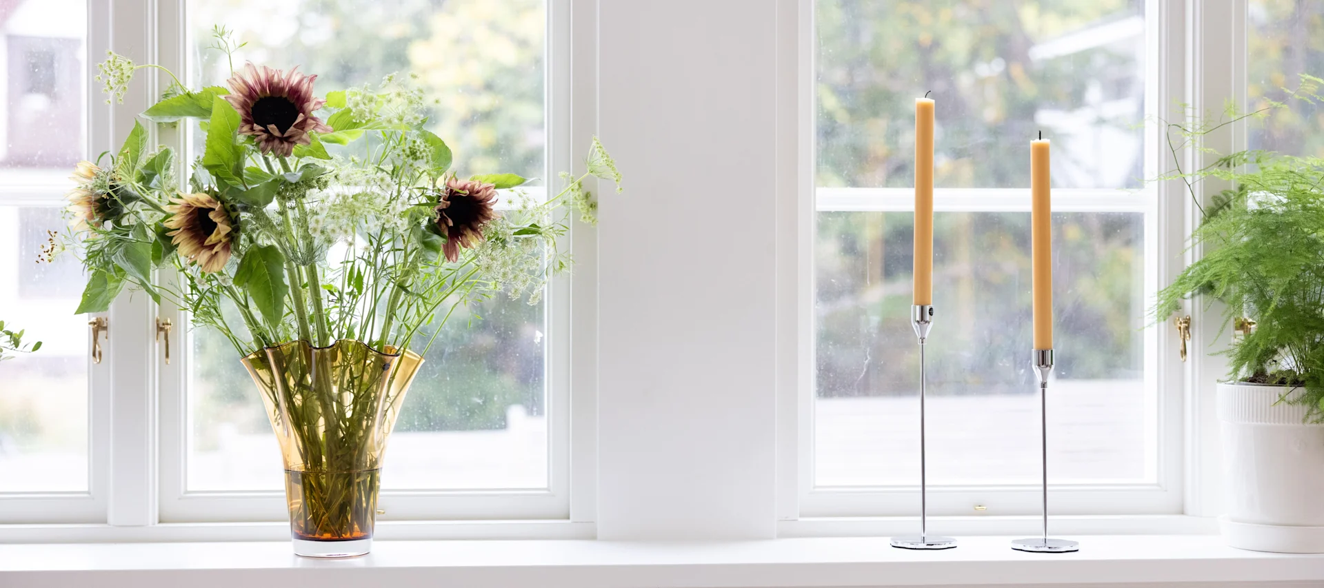 Pynt vinduskarmen ved å gruppere ulike objekter i forskjellige størrelser og høyder, for eksempel en bordlampe, vaser med blomster og lysestaker.
