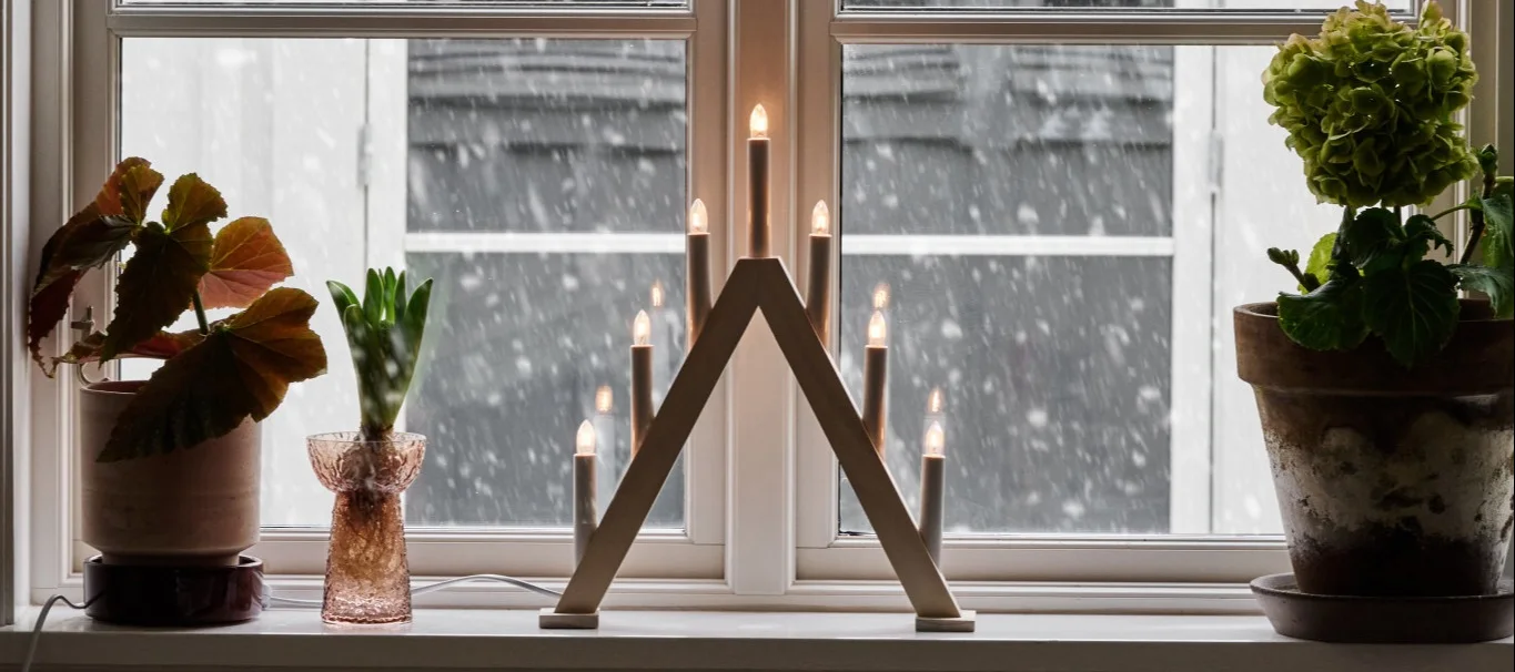 Pynt vinduskarmen ved å gruppere ulike objekter i forskjellige størrelser og høyder, for eksempel en bordlampe, vaser med blomster og lysestaker.
