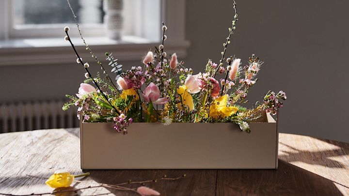 Liten beige Plant Box fra Ferm Living står på bordet med vårblomster i for interiørinspirasjon til våren.