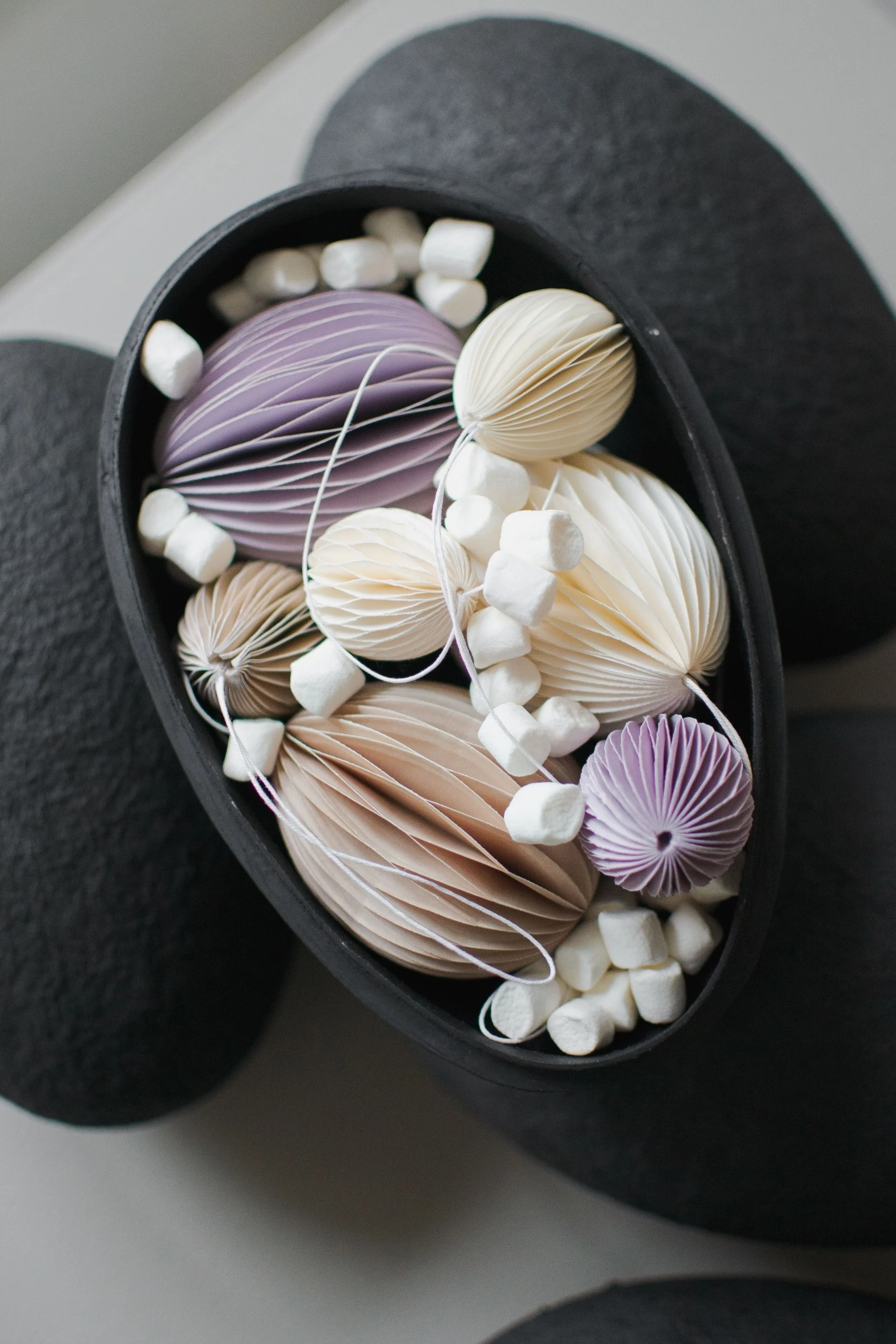 Påskepynt: Her ser du de elegante Ovoid påskeanhengene i papir fra DBKD, i ulike farger, vakkert arrangert i en skål.