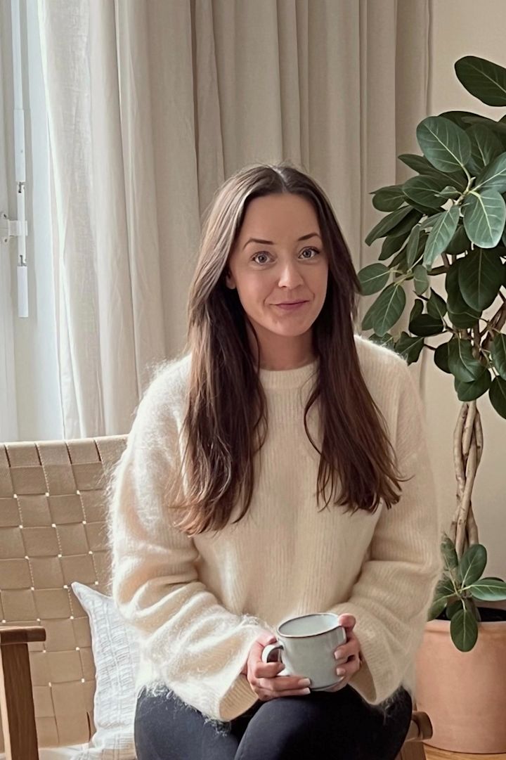 Profilbilde av influenceren Helena Jonsson @helenas.hem sittende i stua si med minimalistisk interiør hvor beige nyanser og natur materialer er tema. 