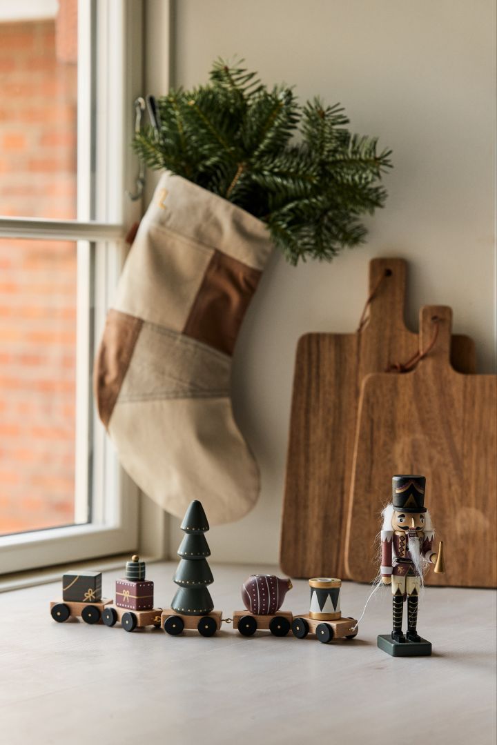 Du kan skape et moderne, minimalistisk julepyntet hjem ved hjelp av Vadim dekorative tog fra Bloomingville og en stilig julestrømpe fra ferm LIVING.