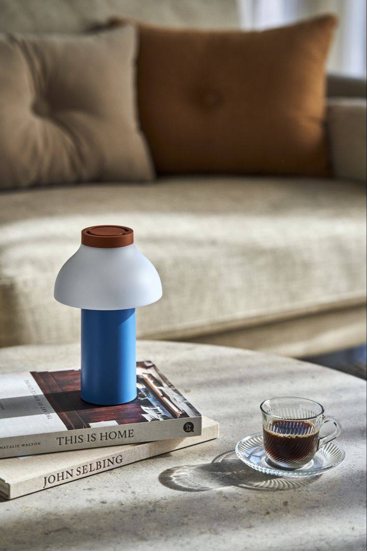 Lekne PC Portable bordlampe i blått, hvitt og brunt ved siden av trendy Pirouette kopp med fat i klarglass fra HAY.