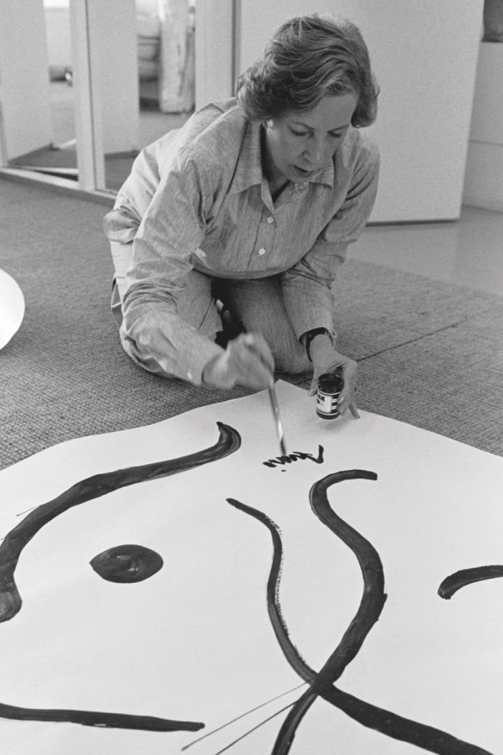 Armi Ratia, grunnleggeren av Marimekko, signerer navnet sitt nederst på et maleri.