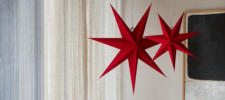 Her kan du se en nykommer blant julestjernene, de rød- og hvitmønstrede stjernene fra Bare-kolleksjonen fra Scandi Living, hengende på en dør.