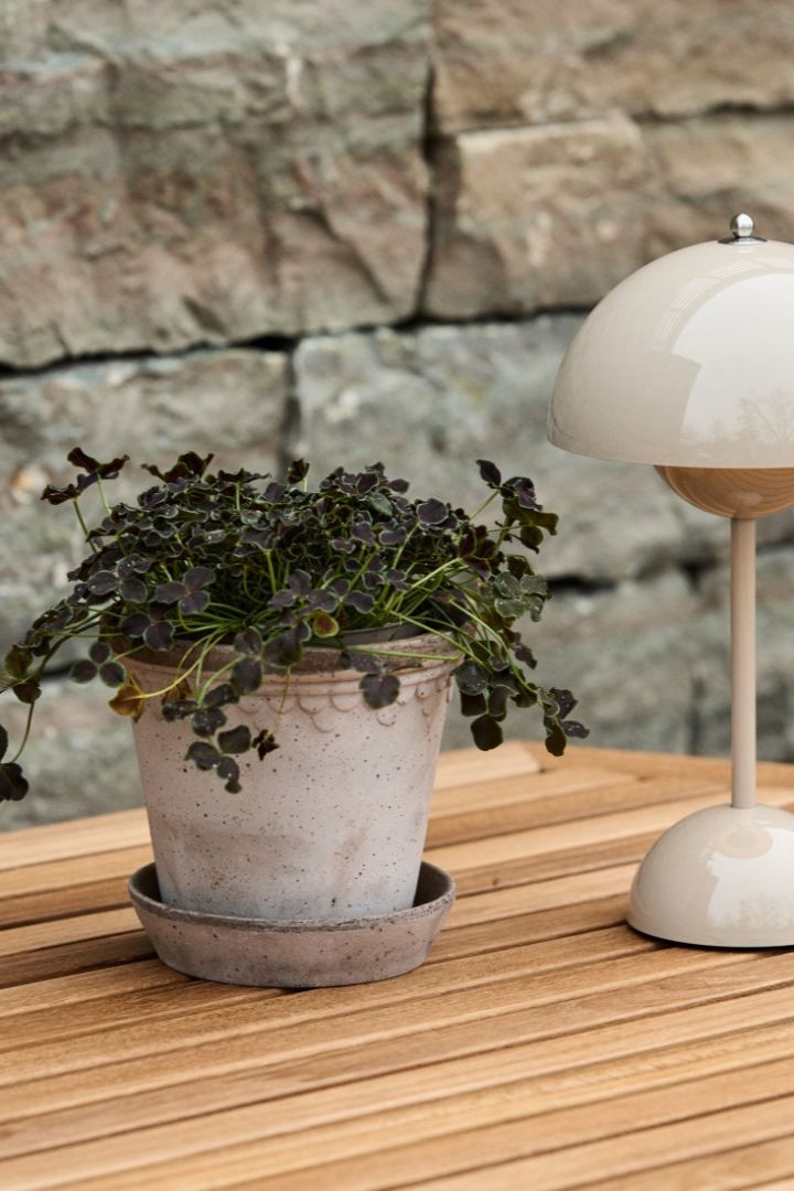 Utendørs plantepotte København står på et spisebord i tre med Flowerpot Vp9 bærbar bordlampe.