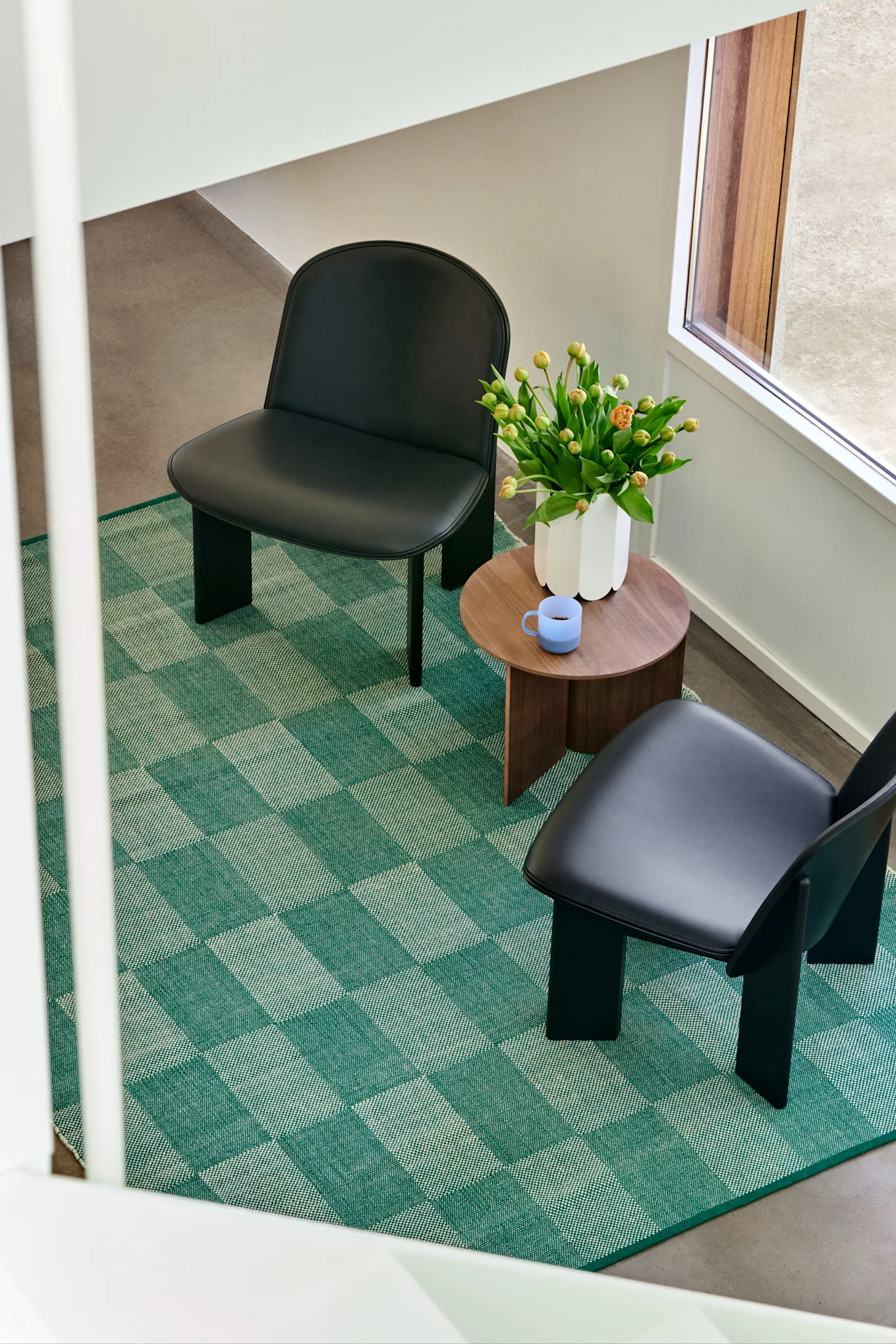 I interiørtrendene våren 2024 ser vi mye mønster, gjerne rutete og stripete i stort og smått. Her ser vi et grønt og rutete teppe fra HAY i et stuemiljø, en interiørdetalj som skiller seg ut og skaper et blikkfang i rommet.