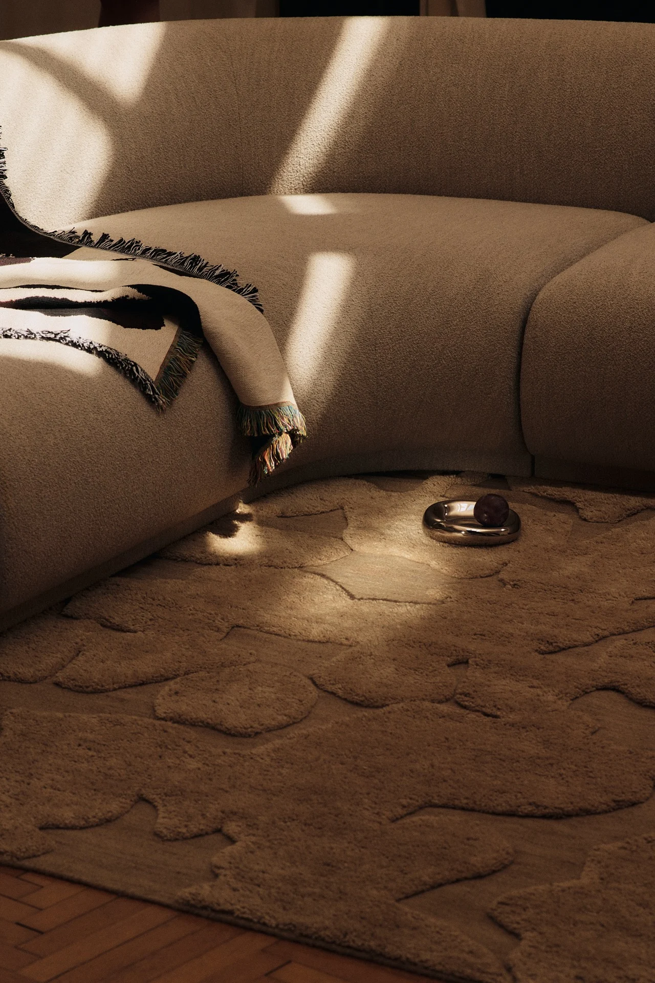 Fargetrender 2026 gjenspeiles i denne stuen, der lysebrune møbler kombineres med et 1960-tallsinspirert teppe i en kombucha-nyanse.
