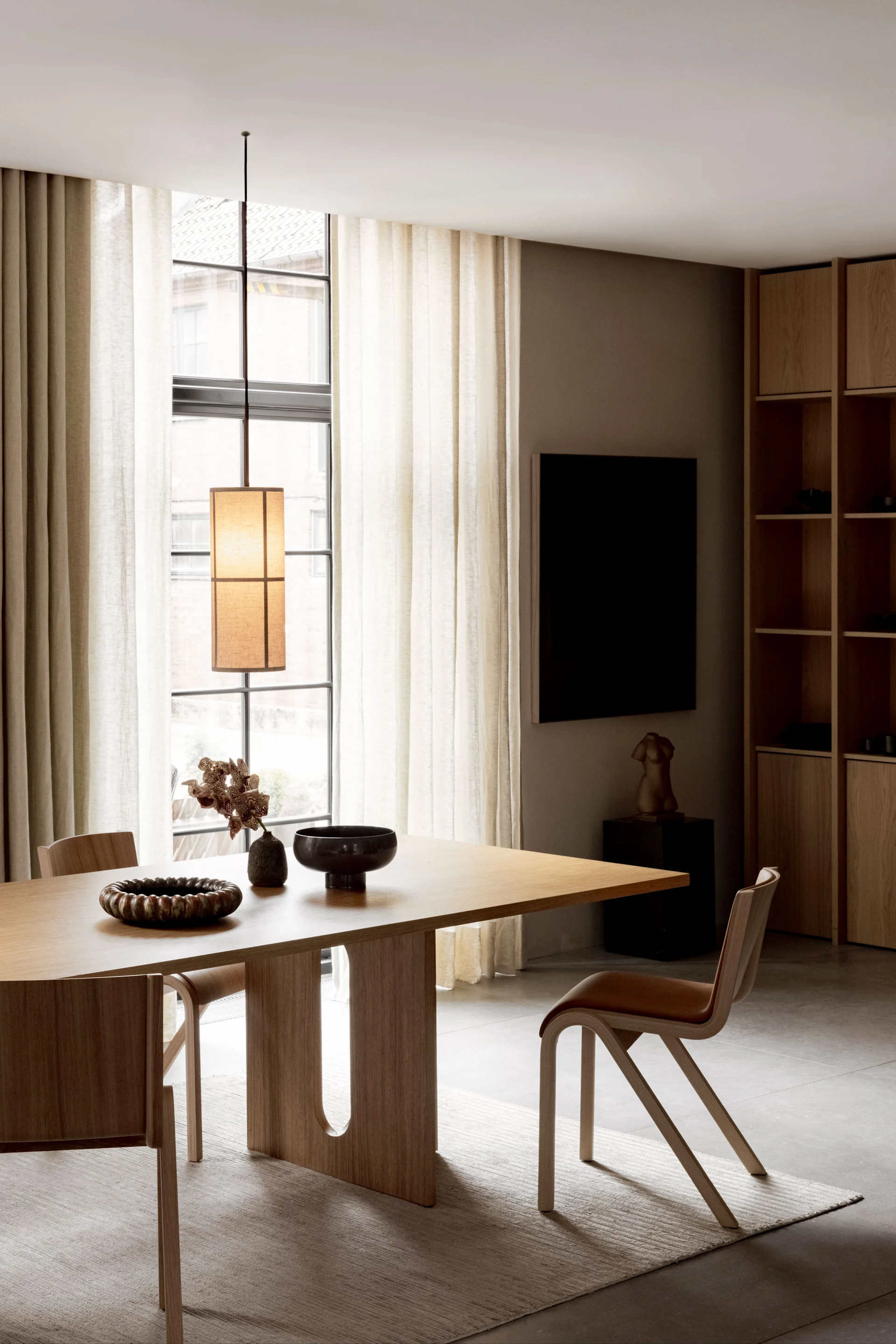 Spiseplass med møbler fra Audo Copenhagen, belyst av Hashira-pendellampe.