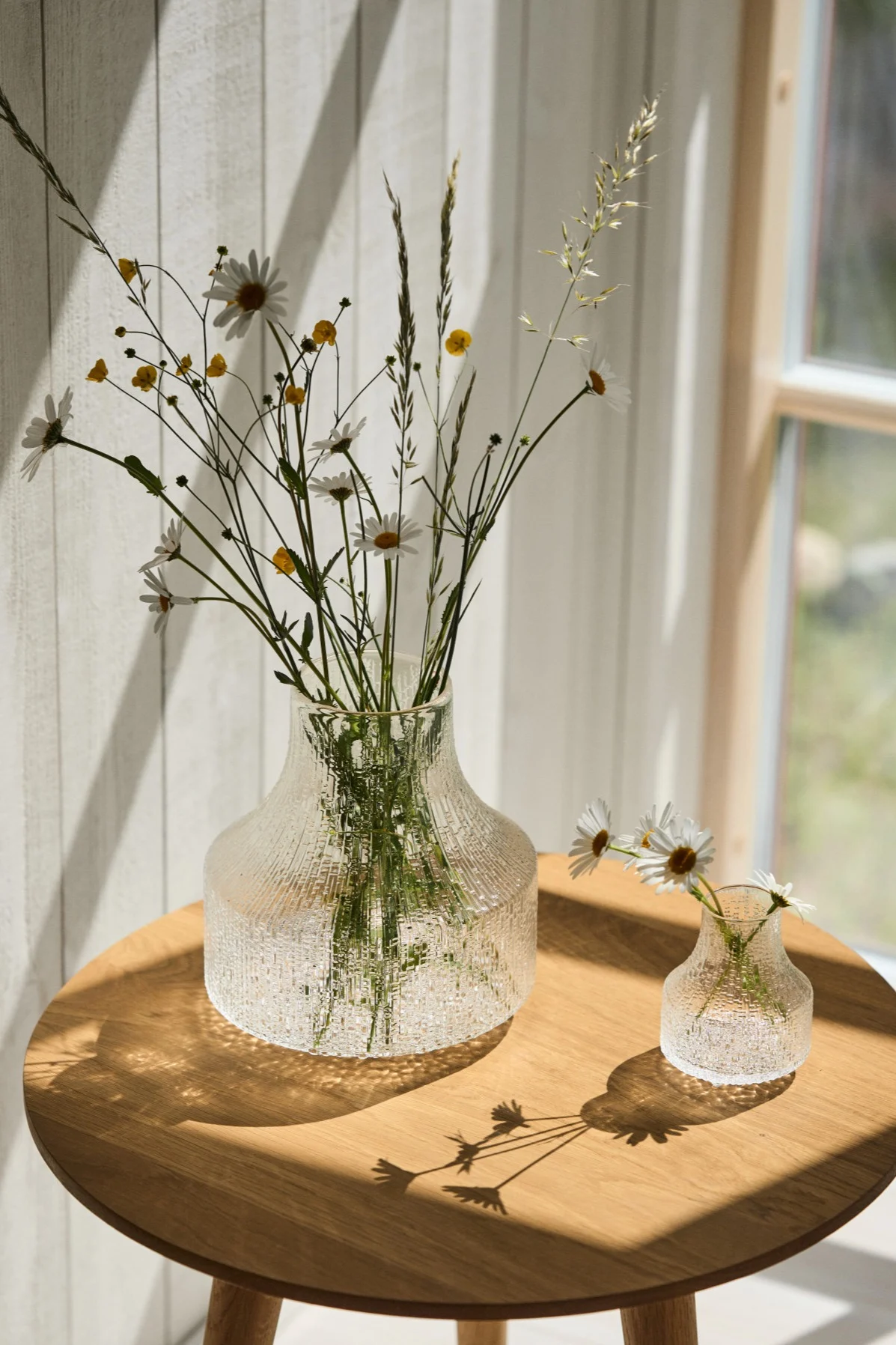 Den beste vasen for små buketter og enkeltblomster er en liten eller minivase – som Ultima Thule-vasene du ser her i solskinnet på bordet.