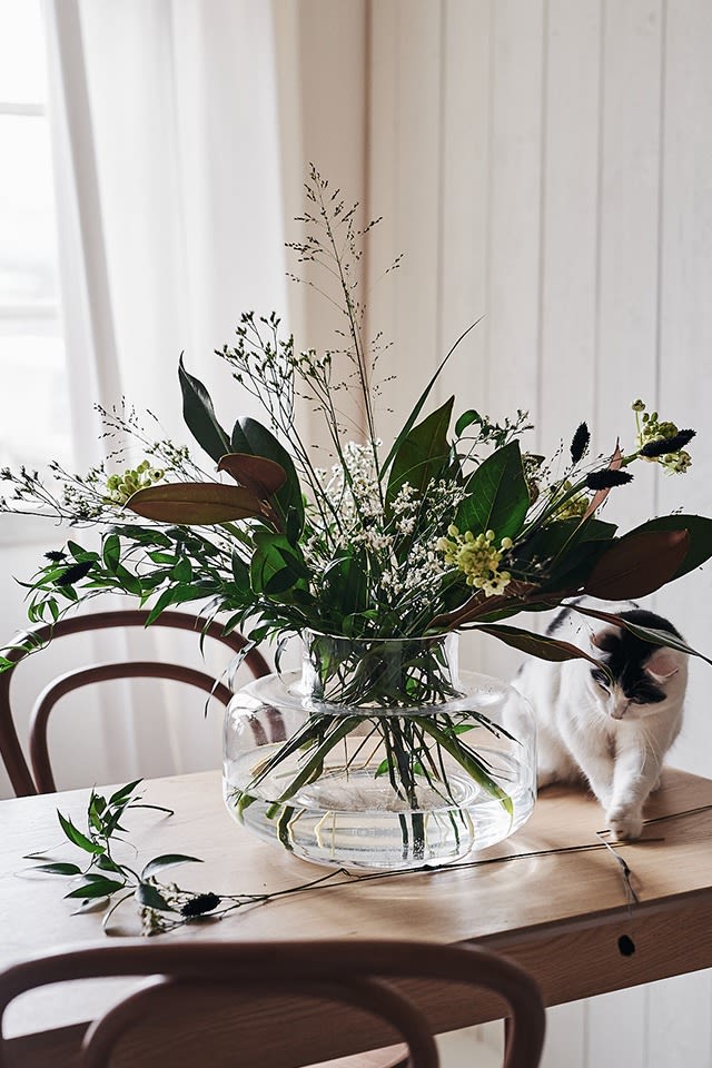 Rund vase til snittblomster fra Marimekko står på bordet med blomster fra Blombruket. 