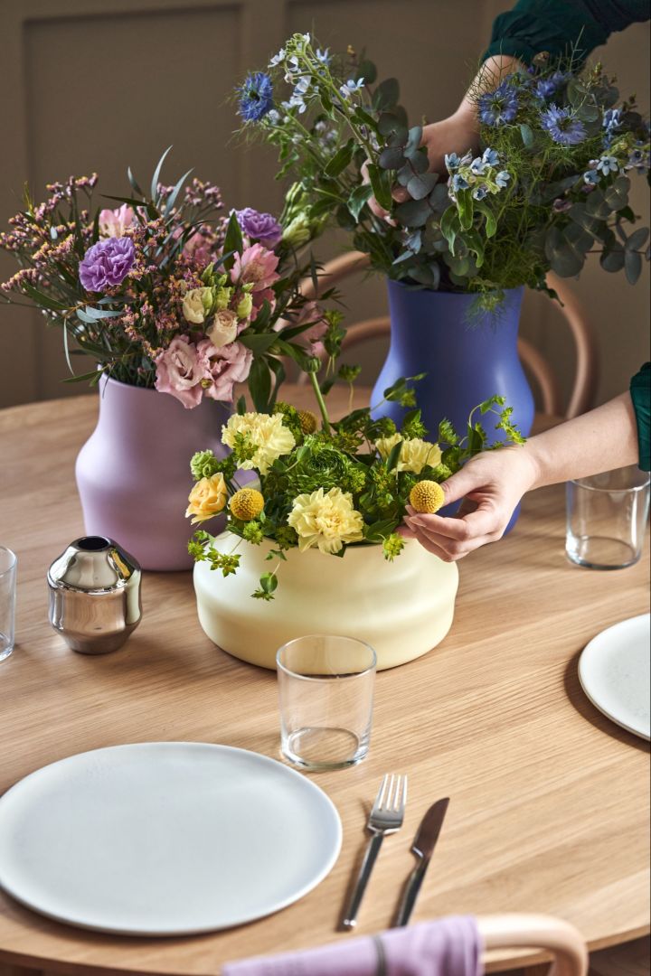 En hånd justerer blomstene i Dorotea-vasene, designet av Monica Förster for Gense.