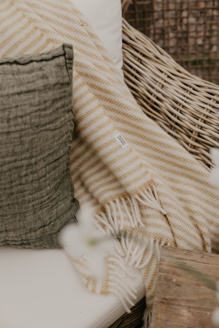 Koselige tekstiler som Hannelin pute fra Himla og Tidal ullteppe fra Scandi Living er perfekt til å innrede drivhus med. Foto: Johanna Berglund, @snickargladjen