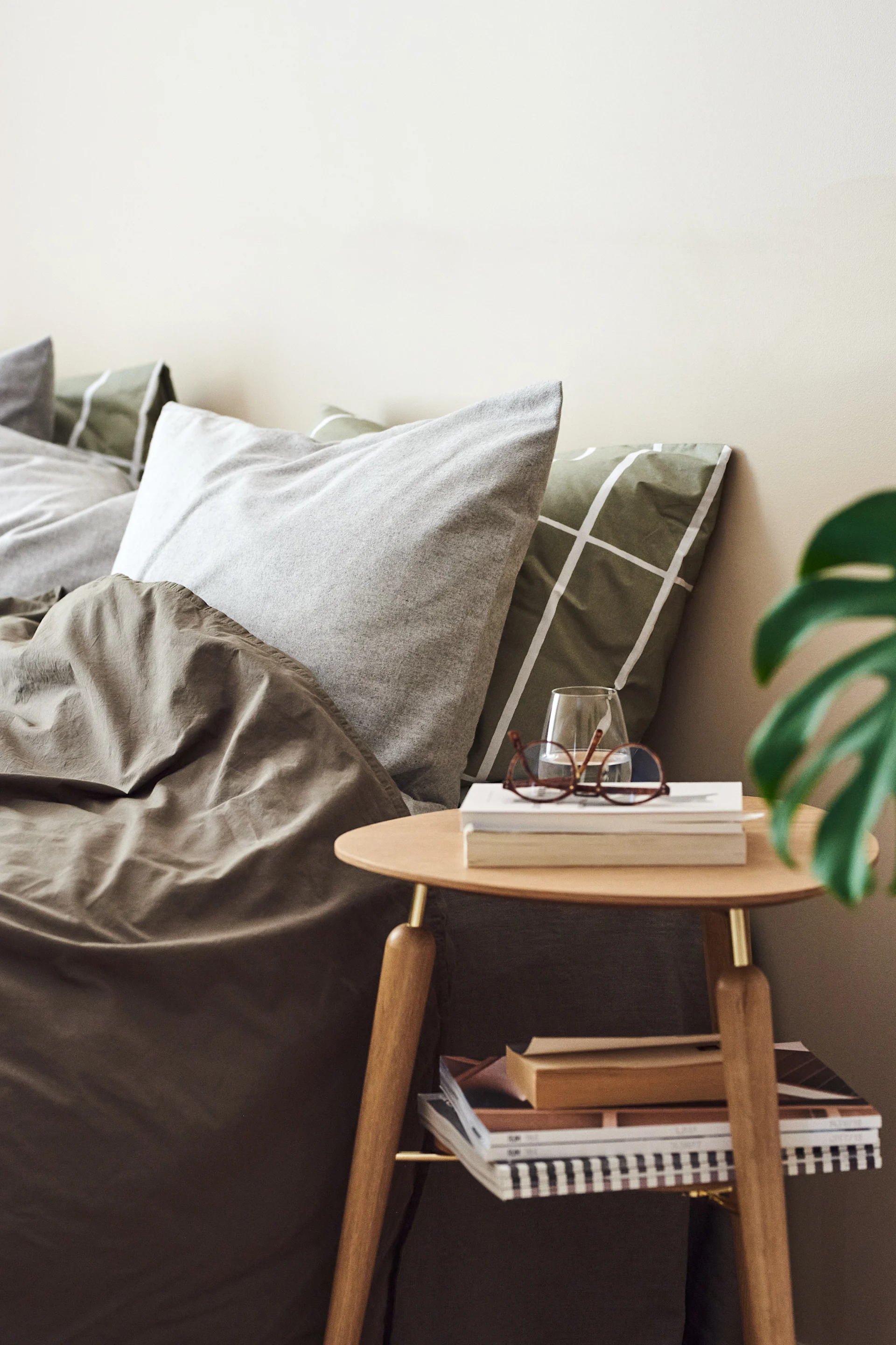 Vakkert sidebord i tre og messing fra Umage i et grønt soverom, perfekt for også å skape hotellfølelse på soverommet.