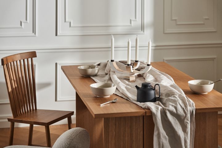 Stilig spiseplass med trebord fra Design House Stockholm, Family stol, linduker og servise i form av skåler og tekanne i sort.